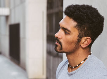 Close-up of young man looking away in alley