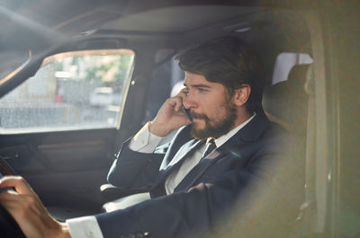 Businessman using mobile phone while sitting in car