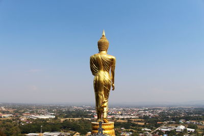 Statue against buildings in city