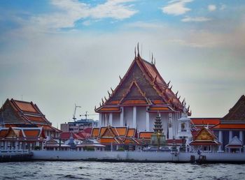 Temple by building against sky