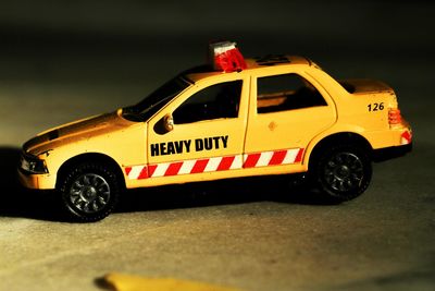 Close-up of toy taxi on footpath at night