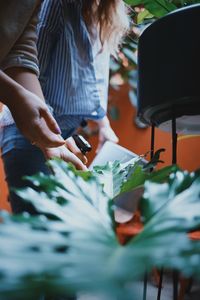 Cropped image of women watering plants