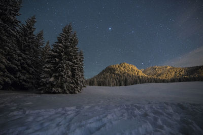 Scenic view of snowcapped mountains against sky at night