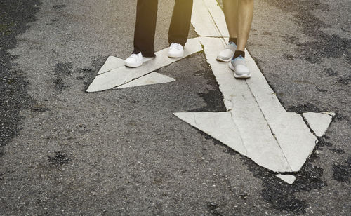 Low section of man walking on road