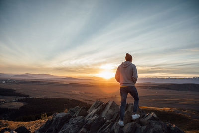 Rear view of man standing on cliff