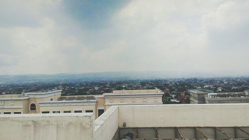 Buildings against cloudy sky