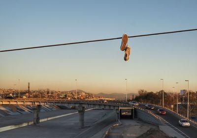 Pair of shoes hanging on cable with city in background