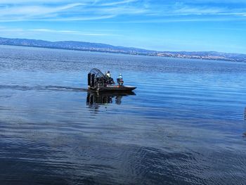 Men on boat in sea against sky