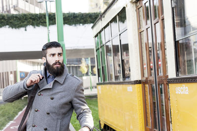 Portrait of young man standing in train