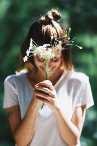 Midsection of woman holding flower