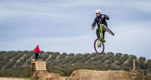 Low angle view of man jumping while doing bmx cycling