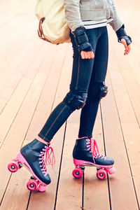 Low section of teenage girl roller skating on boardwalk