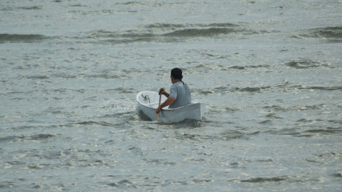 Rear view of man sitting at beach