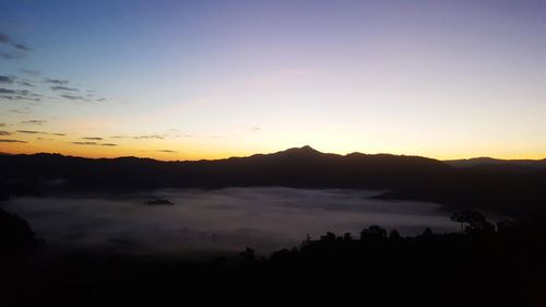 Scenic view of silhouette mountains against sky during sunset