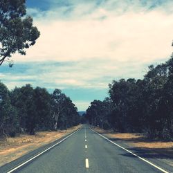 Empty road against cloudy sky