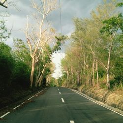 Road amidst trees against sky