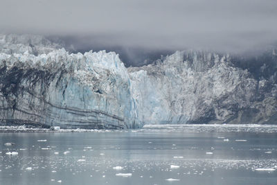 Ancient glacier and foggy dramatic sky in alaska ocean bay
