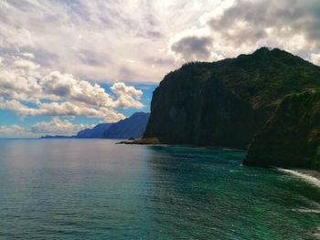 Scenic view of sea and mountains against sky