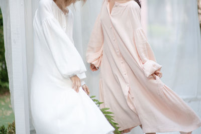 Midsection of friends with plant at studio