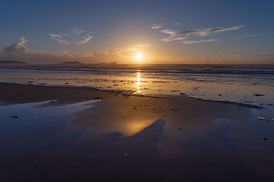 Scenic view of beach against sky during sunset