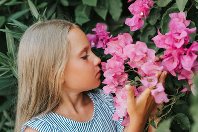 Portrait face of candid little kid girl of eight years old on background of green plants