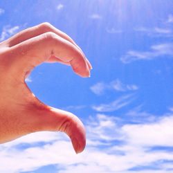 Low angle view of cropped hand against clear sky