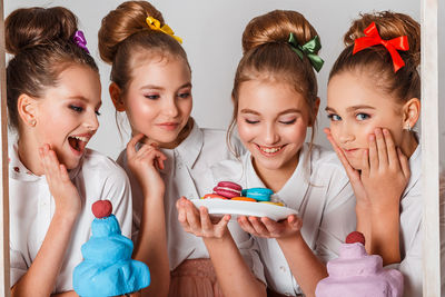 Happy friends with sweet food against white background