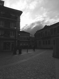 Buildings against cloudy sky