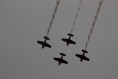 Low angle view of airshow against sky