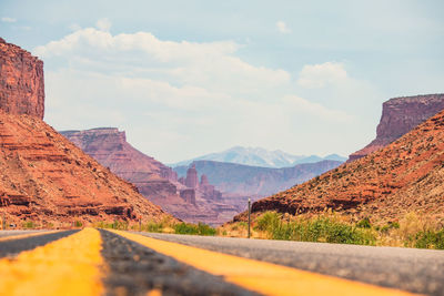 Road leading towards mountains against sky