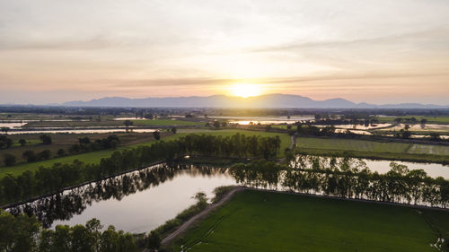Scenic view of river against sky during sunset