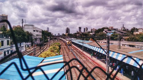 Train on railway tracks in city against sky