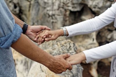 Midsection of couple holding hands