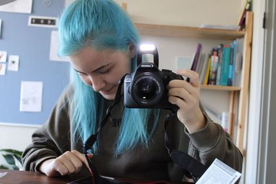 Portrait of woman holding camera