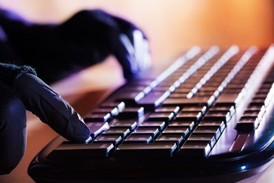 Cropped hands of person typing on computer keyboard