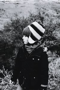 Rear view of boy standing on snow field