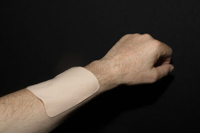 Close-up of human hand against black background