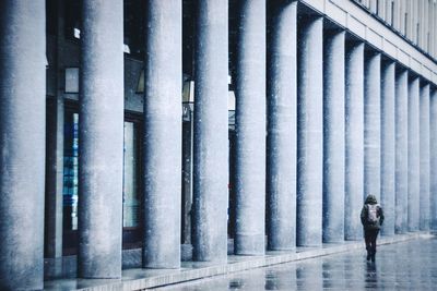 Rear view of woman walking on street against building