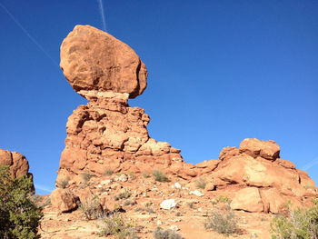 Low angle view of rock formation against clear blue sky