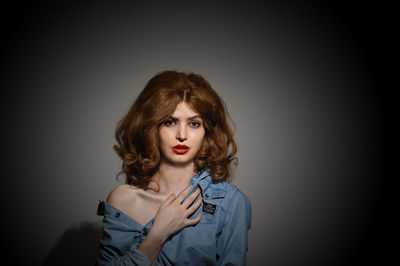 Portrait of young woman against gray background