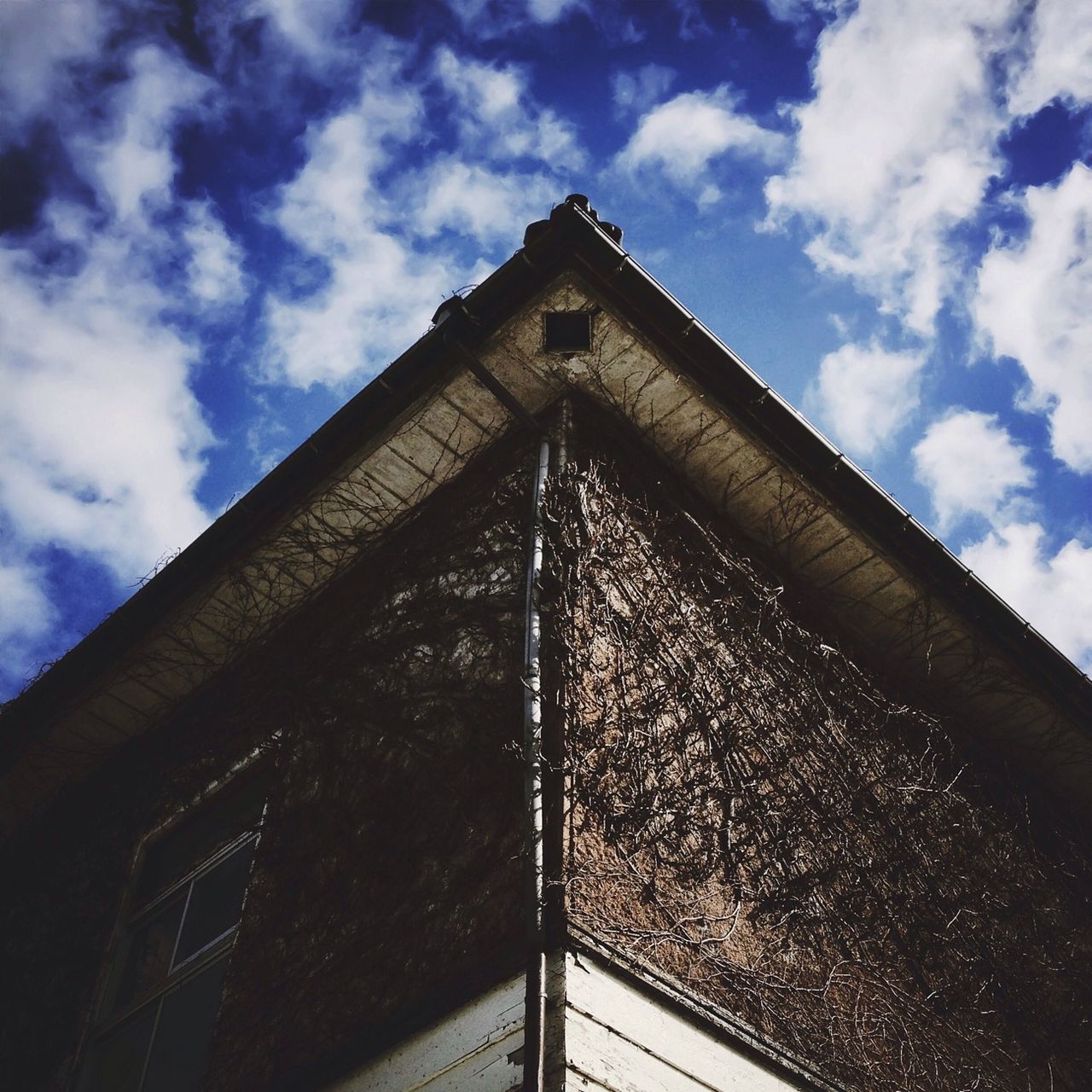 low angle view, architecture, built structure, sky, building exterior, cloud - sky, cloud, window, day, no people, outdoors, cloudy, building, wall - building feature, railing, sunlight, high section, metal, old, pattern