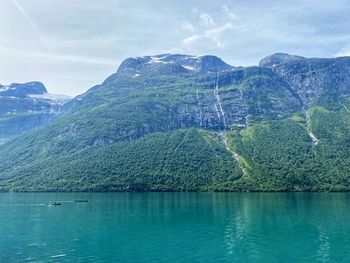 Scenic view of lake by mountain against sky