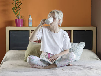 Girl sitting on bed at home