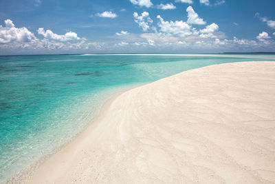 Scenic view of white clear sand and turqoise water beach against sky on gusung island derawan