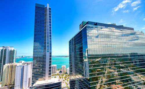 Low angle view of modern buildings against blue sky