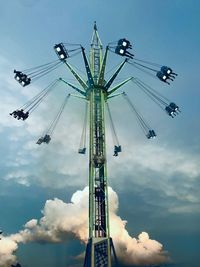 Low angle view of chain swing ride against sky