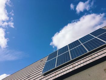 Low angle view of solar panels against blue sky