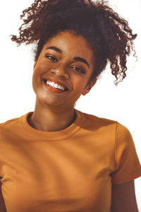Portrait of young woman with curly hair against white background