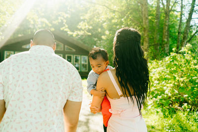 View from behind of a young family walking together on a summer's day