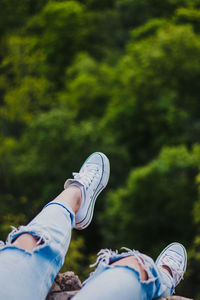 Fashionable legs hanging over great forest 